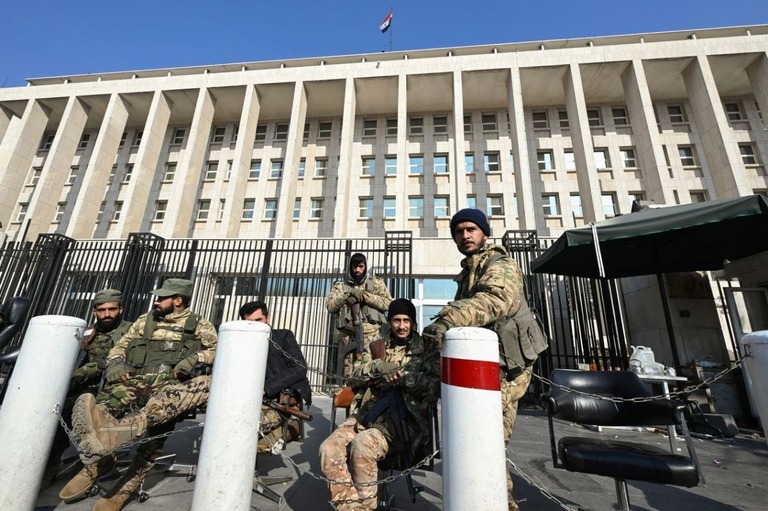 シリア首都ダマスカスにある中央銀行前を警護する反体制派の兵士ら/Louai Beshara/AFP/Getty Images