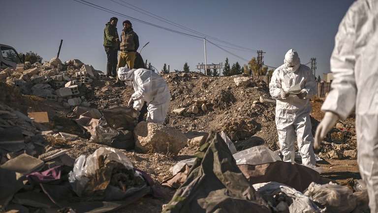 シリアのボランティア救助組織「ホワイトヘルメッツ」がダマスカスで見つかった集団墓地で遺体を収容する様子＝１６日/Aris Messinis/AFP/Getty Images