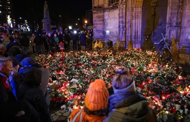 事件現場の近くにある教会の外で犠牲者に手向けられた花/Ronny Hartmann/AFP/Getty Images