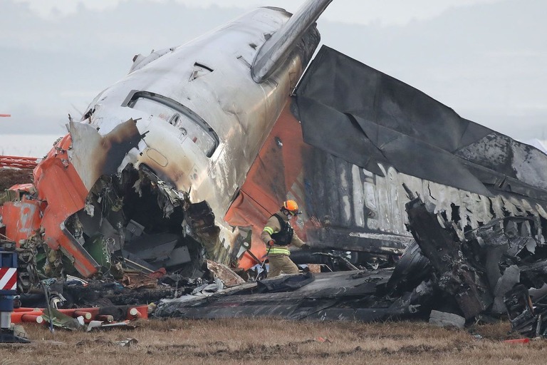 務安国際空港に墜落した旅客機の残骸の周辺で作業する消防隊員/Chung Sung-Jun/Getty Images via CNN Newsource