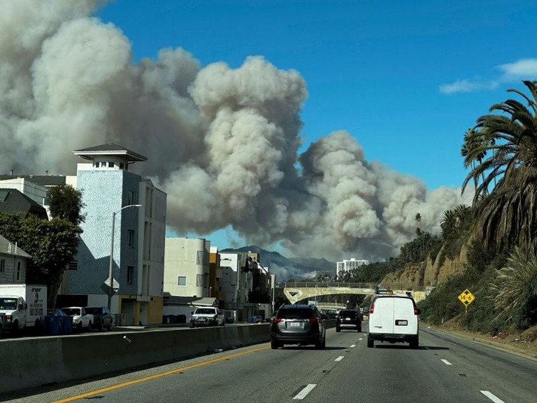 米加州の高級住宅地パシフィック・パリセーズから立ち上る山火事の煙/AP Photo/Eugene Garcia