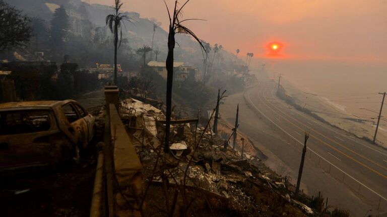 ロサンゼルスの住宅地パシフィック・パリセーズの上空に朝日が昇る様子＝９日/Maria Alejandra Cardona/Reuters