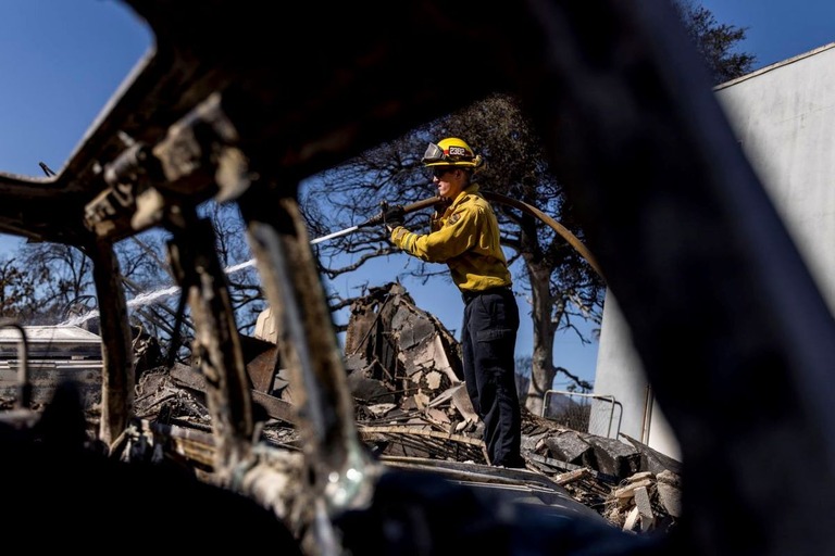 イートン火災により焼失した住宅の消火活動に当たる消防隊員/Stephen Lam/San Francisco Chronicle/Getty Images