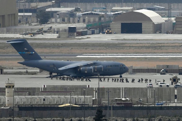 アフガン首都カブールの空港で米空軍の輸送機に乗り込む米兵ら＝２０２１年８月３０日/Aamir Qureshi/AFP/Getty Images