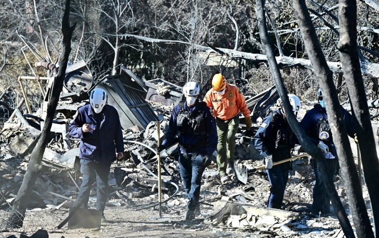 イートン地区でがれきと化した住居の周辺を捜索する救助隊員ら＝１５日/Frederic J. Brown/AFP/Getty Images