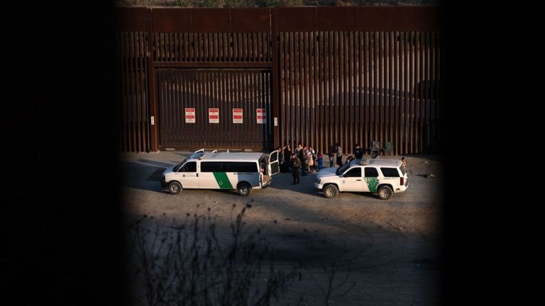 メキシコ・ティフアナ側から見た、国境警備隊サンディエゴ部門の職員による移民手続きの様子＝２０日/Guillermo Arias/AFP/Getty Images