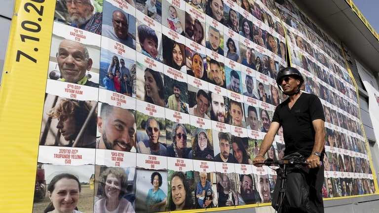 人質の写真を示した建物のそばを通る男性＝３月２６日、テルアビブ/Amir Levy/Getty Images