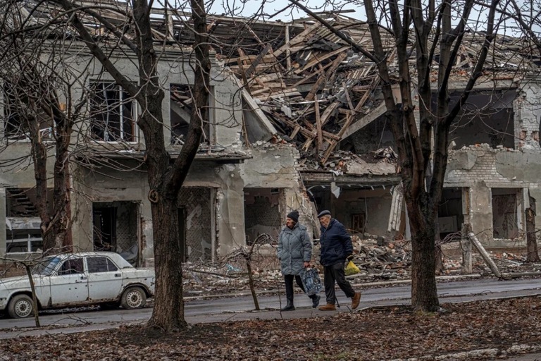 ロシア軍の空爆によって破損した建物の前を歩く住民＝１月、ウクライナ・ポクロウスク/Anton Shynkarenko/Reuters