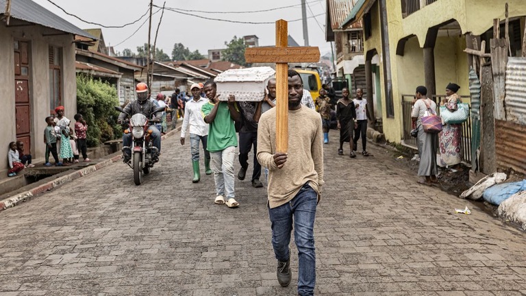 ４日、ゴマ市内での葬列で十字架を掲げて歩く男性/Michel Lunanga/AFP/Getty Images