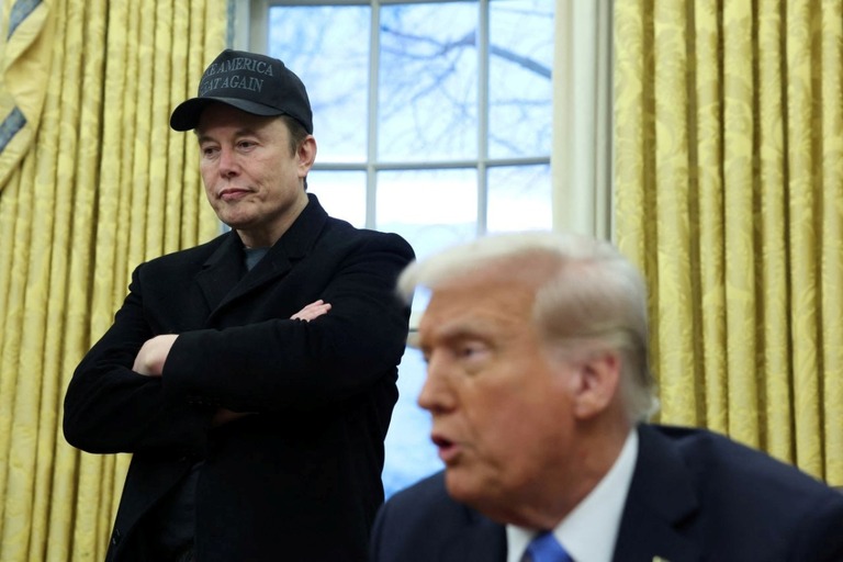 ホワイトハウスの執務室でトランプ大統領の発言に耳を傾けるイーロン・マスク氏/Kevin Lamarque/Reuters