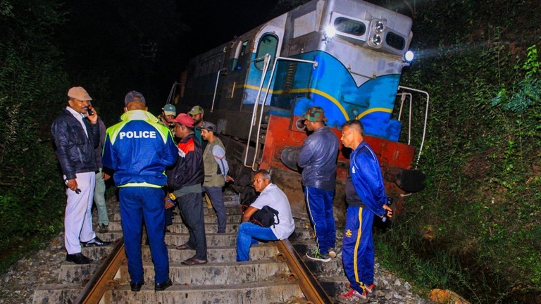 脱線した列車を調査する警察と鉄道職員ら＝２０日、スリランカ東部/-/AFP/AFP via Getty Images