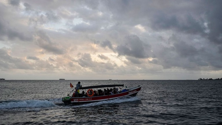 米国入りを断念した移民を乗せ、パナマの島からコロンビアへ向かう船/Matias Delacroix/AP